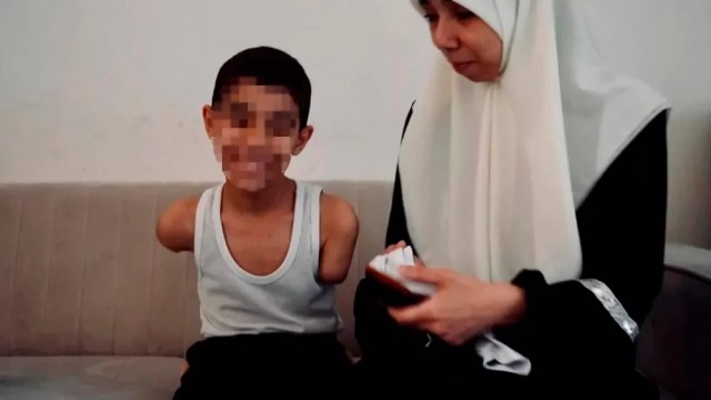 Mahmoud Ajjour, 9 anos, sorri ao lado de sua mãe. Ele perdeu os braços sob as bombas israelenses em Gaza