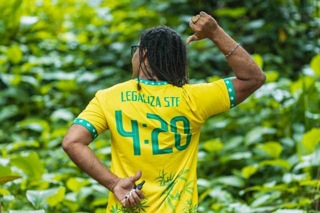 O jornalista e ativista pela legalização da maconha, Luan Cândido, mostra as costas da camiseta que está vestindo, com os dizeres "LEGALIZA STF - 4:20"