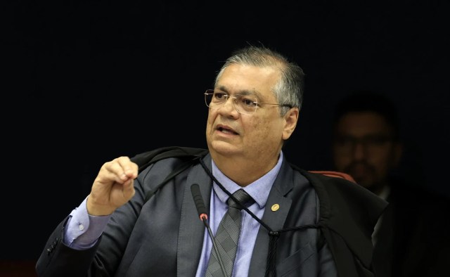 Ministro do STF durante julgamento dos envolvidos nos atos golpistas de 8/1; falando e com a toga preta em sessão no plenário.