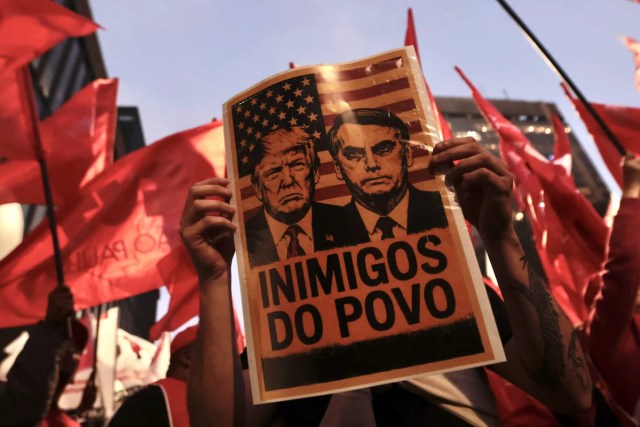 Cartaz com a foto do presidente Donald Trump e o ex-presidente Jair Bolsonaro, durante protesto à atuação do Congresso Nacional na justiça tributária com a taxação dos super ricos, fim da escala 6×1 e a isenção de Imposto de Renda para quem ganha até R$ 5 mil, realizado em frente ao MASP
