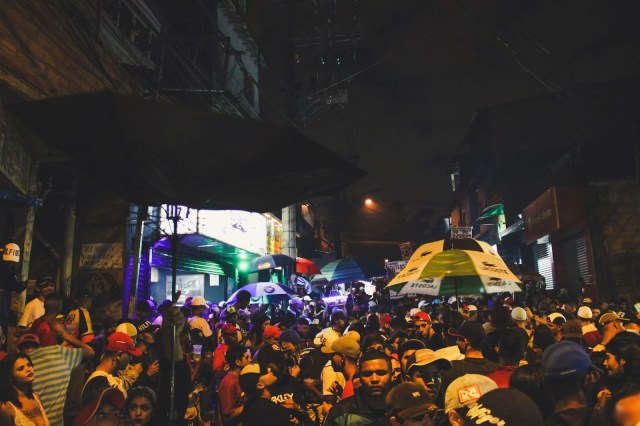 Multidão ocupa a rua durante baile funk em Paraisópolis, cenário frequentemente marcado pela presença da violência policial.