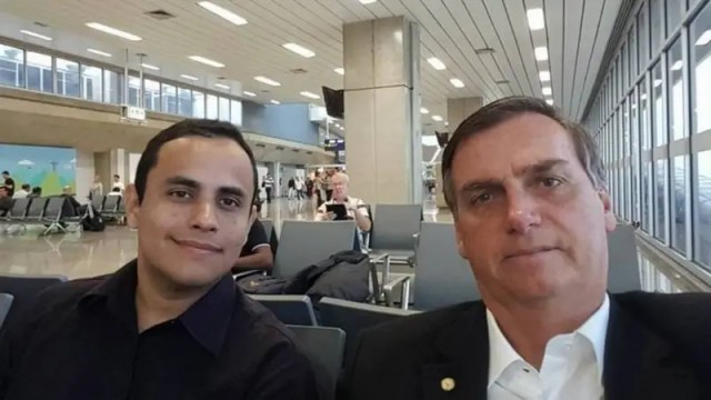 Jair Bolsonaro ao lado de 3. Tércio Arnaud Tomaz em aeroporto, ambos citados em investigações ligadas ao julgamento STF sobre a tentativa de golpe.